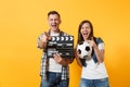 Young excited couple woman man football fans cheer up support team with soccer ball, film making clapperboard isolated Royalty Free Stock Photo