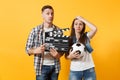 Young excited couple woman man football fans cheer up support team with soccer ball, film making clapperboard isolated Royalty Free Stock Photo