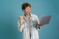 Young excited man using laptop while pointing finger aside Royalty Free Stock Photo