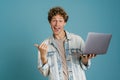 Young excited man using laptop while pointing finger aside Royalty Free Stock Photo