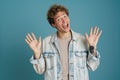 Young excited man wearing jacket gesturing and exclaiming