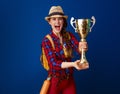 Young excited woman hiker isolated on blue showing goblet