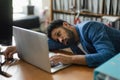 Young exhausted male employee in front of notebook in his office.