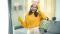 Young exhausted and tired housekeeper wearing yellow shirt in living room