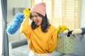 Young exhausted and tired housekeeper wearing yellow shirt in living room