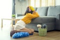 Young exhausted and tired housekeeper wearing yellow shirt in living room