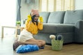 Young exhausted and tired housekeeper wearing yellow shirt in living room