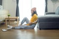 Young exhausted and tired housekeeper wearing yellow shirt in living room