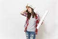 Young exhausted woman in newspaper hat holding wallpaper roll and paint brush and keeping hand near face isolated on Royalty Free Stock Photo