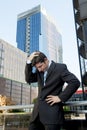 Young exhausted and worried businessman standing outdoors in stress and depression Royalty Free Stock Photo