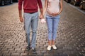 Young expectant parents holding hands while posing with baby booties Royalty Free Stock Photo