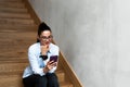 Young expert business woman sitting at the staircase texting and calling her boss to tell that the meeting was well and the deal Royalty Free Stock Photo