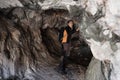 Young explorer in black sportswear in a cave with climbing equipment ready for action