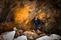 Young explorer with headtorch, venturing deep inside a Himalayan cave in Uttarakhand. Thrilling underground adventure. Stock photo