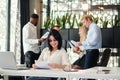 Young exuberant female office worker looking at camera with lovely smile at her workplace in meeting room