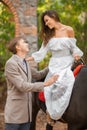 A young fall in love couple on a date outdoor. Woman and man with horse walking in autumn park. Royalty Free Stock Photo