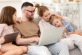 Young family addicted with gadgets relaxing on sofa at home Royalty Free Stock Photo