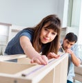 Young family assembling furniture at new house