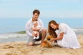 Young family with a baby and dog relax on the beach Royalty Free Stock Photo