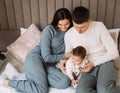 Young family with a baby, lie on the bed, have fun. Concept of childhood, love and family. Royalty Free Stock Photo