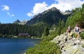 A young family with baby in a sling hiking near Popradske Pleso mountain lake in High Tatras, Slovakia Royalty Free Stock Photo