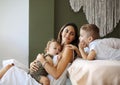 Young family beautiful mother with two son of different ages spending time at home, loving mom Royalty Free Stock Photo