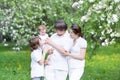 Young family in a blooming apple tree garden Royalty Free Stock Photo