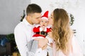 Family celebrates Christmas at home in the living room near the Christmas tree. Happy mom, dad and son enjoy their vacation togeth Royalty Free Stock Photo