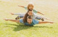 Young family with child having fun in nature. Fly concept, little boy is sitting pickaback while imitating the flight.