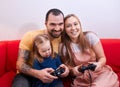 Young family with child play video game together Royalty Free Stock Photo