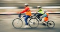 Young family with a child ride a bikes on a city streets Royalty Free Stock Photo