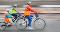 Young family with a child ride a bikes on a city streets Royalty Free Stock Photo