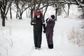 A young family with a child walking through a snow-covered forest. Royalty Free Stock Photo