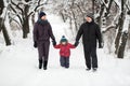 A young family with a child walking through a snow-covered forest. Royalty Free Stock Photo