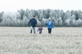 Young family with child walks in winter field