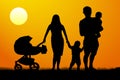 A young family with children silhouette at sunset. A man and a woman with two children Royalty Free Stock Photo