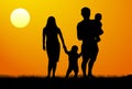 A man and a woman with two children, at dawn. Royalty Free Stock Photo