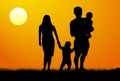 A young family with children silhouette at sunset