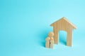 A young family with children is standing near a wooden house. The concept of a strong family, the continuation of the family.