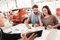 Young Family Are Choosing A New Car In Showroom. Royalty Free Stock Photo