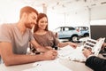 Young Family Are Choosing A New Car In Showroom. Royalty Free Stock Photo