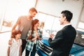 Young Family Are Choosing A New Car In Showroom. Royalty Free Stock Photo