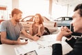 Young Family Are Choosing A New Car In Showroom. Royalty Free Stock Photo