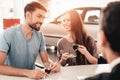 Young Family Are Choosing A New Car In Showroom. Royalty Free Stock Photo