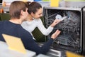 Young family choosing new dish washing machine in supermarket Royalty Free Stock Photo