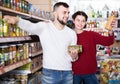 young family choosing purchasing canned food for week at supermarket Royalty Free Stock Photo