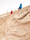 Young family climbing a sand dune Royalty Free Stock Photo