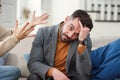 Nervous young man trying to doesn`t listen to his girlfriend in the bedroom. Royalty Free Stock Photo