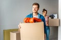 Young family couple bought or rented their first small apartment. Cheerful man and woman carry boxes with stuff. Smile Royalty Free Stock Photo