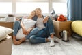 Young family couple bought or rented their first small apartment. People sit on floor and sleep. Tired and exhausted Royalty Free Stock Photo